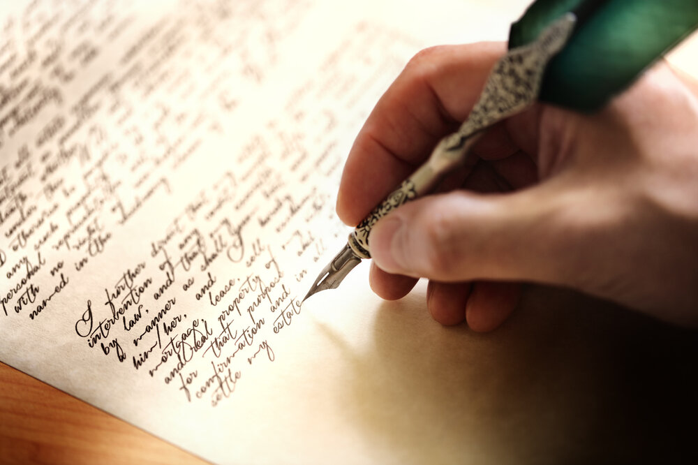 Eine Hand, die einen Federstift hält.
