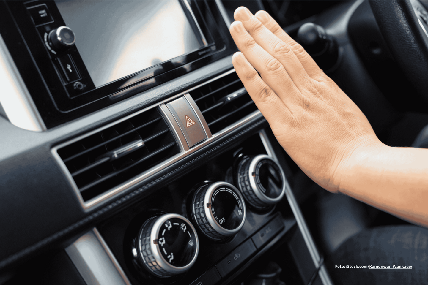 Das Foto zeigt eine Klimaanlage im Auto und eine Person, die ihre Hand davor hält.